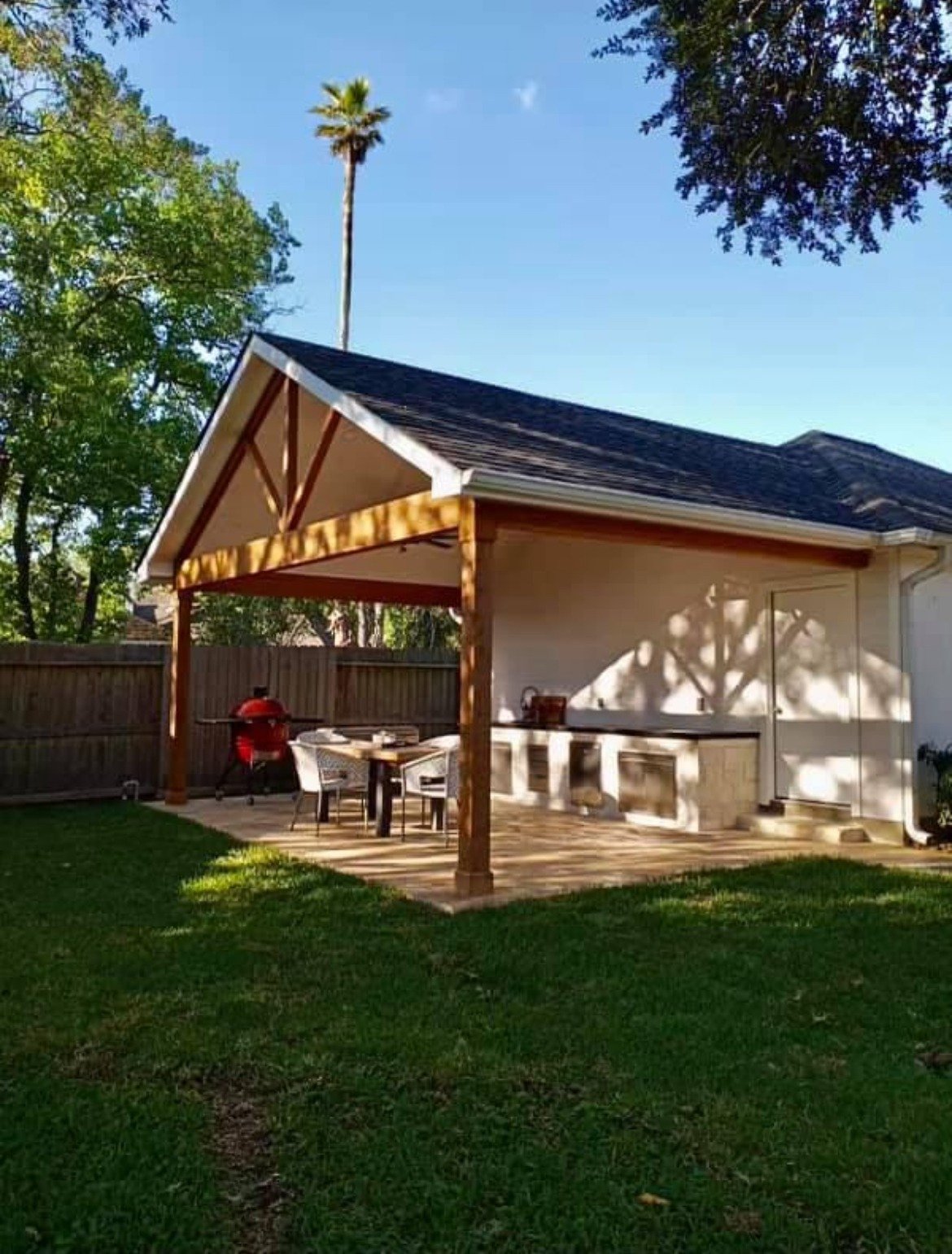 Gable patio cover with cedar beams over a patio and outdoor kitchen